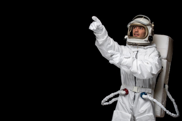 Космонавт дня космонавта в космическом космосе в скафандре, показывая где-то взволнованный удивленный
