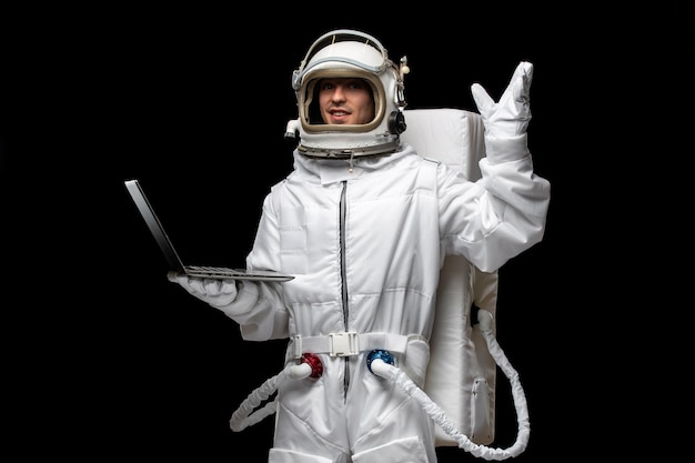 Astronaut day spaceman in white space suit costume open glass helmet holding computer raised hand
