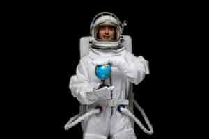 Free photo astronaut day spaceman in white space suit smiling open glass helmet holding and spinning globus