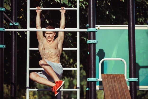 Athlete doing exercises at stadium at park