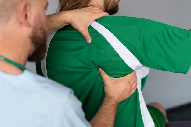 Foto gratuita atleta che fa vista laterale di fisioterapia