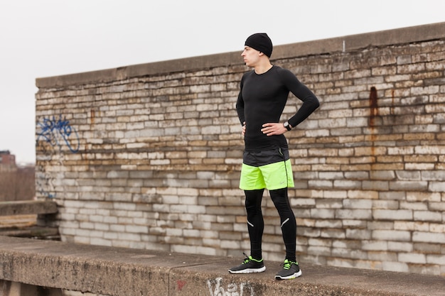 Foto gratuita atleta di fronte a un muro