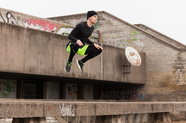 Free photo athlete jumping on rooftop