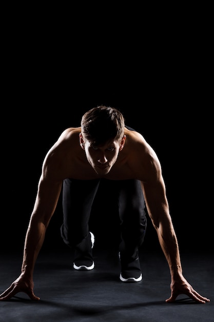 Il corridore dell'atleta si prepara a correre dall'inizio accovacciato