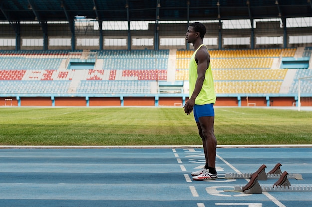 Free photo athlete on the starting line at the stadium