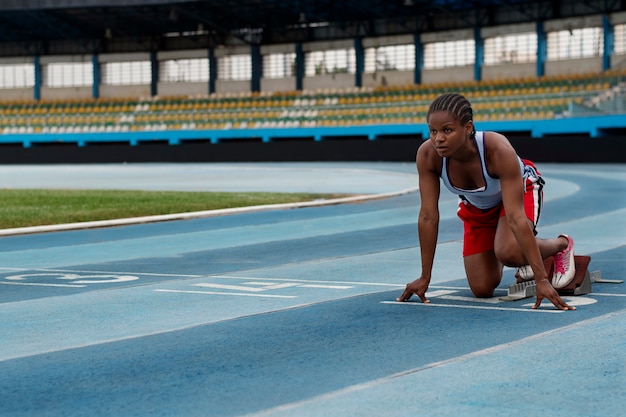 Free photo athlete on the starting line at the stadium