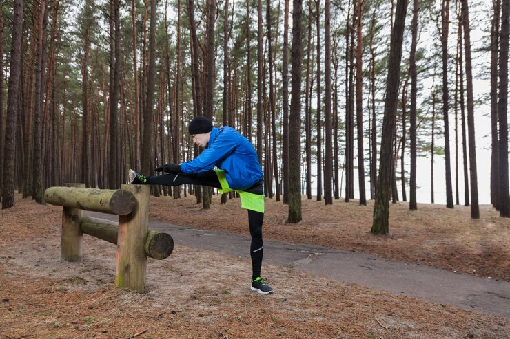 Free Photo athlete stretching leg in forest