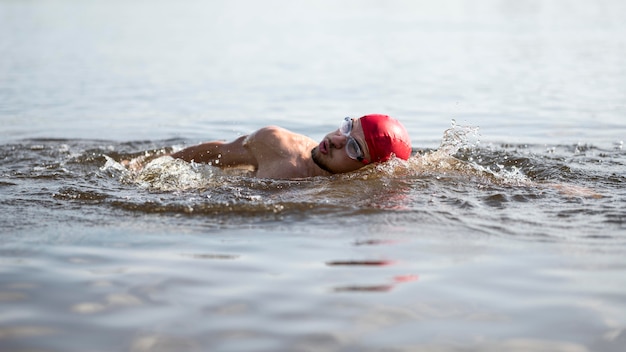 Спортсмен купается в озере