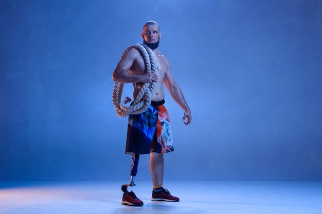 Athlete with disabilities or amputee isolated on blue studio wall