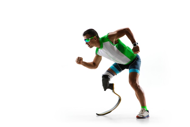 Free photo athlete with disabilities or amputee isolated on white studio background. professional male runner with leg prosthesis training and practicing in studio. disabled sport and healthy lifestyle concept.