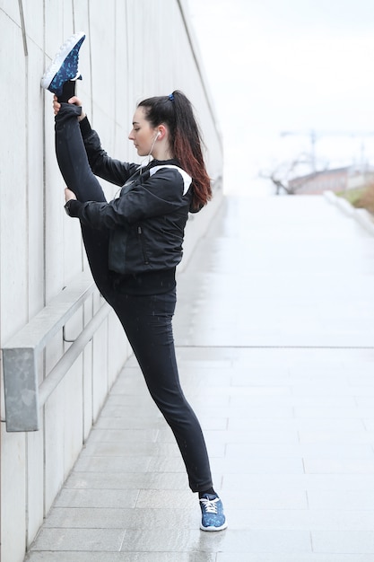 Athlete woman doing stretching in the street