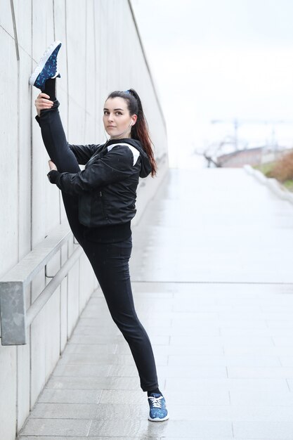 Athlete woman doing stretching in the street