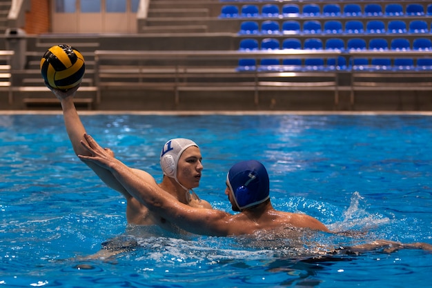 Athletes playing water polo in the pool