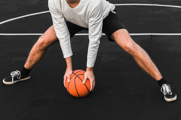 Giocatore di pallacanestro atletico che si esercita sulla corte