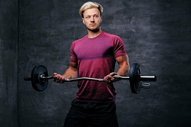 Athletic blond male doing a biceps workout with a barbell.