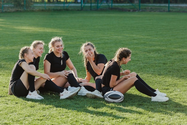 Athletic blonde women sitting on grass