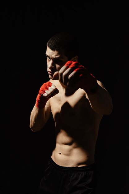 Athletic boxer punching with determination and precaution