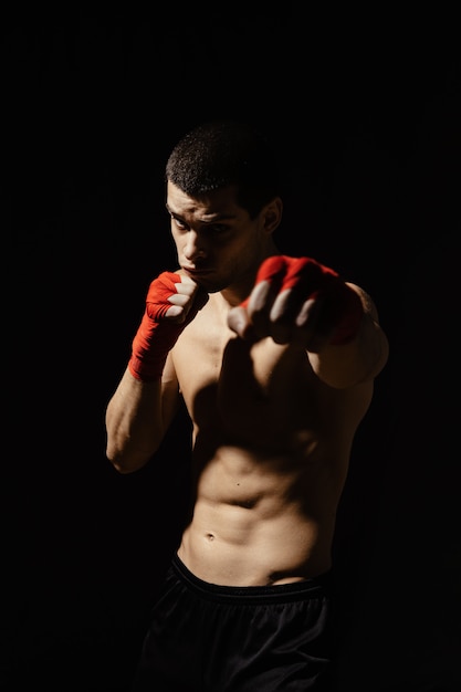 Athletic boxer punching with determination and precaution