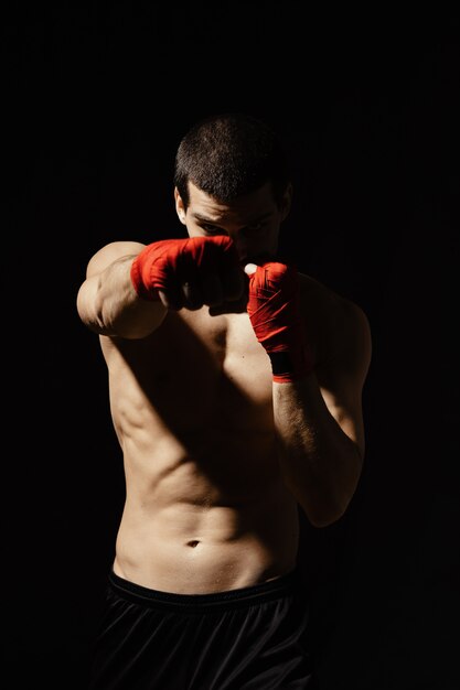 Athletic boxer punching with determination and precaution