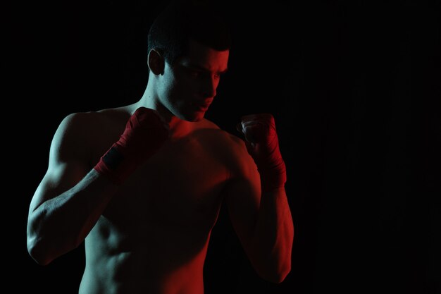 Athletic boxer punching with determination