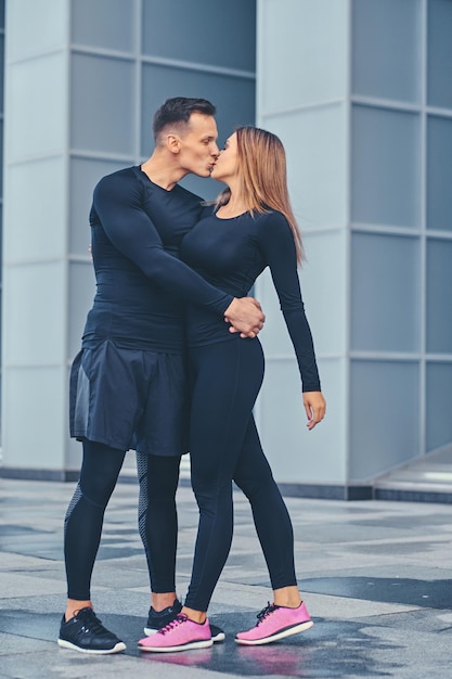 The athletic fitness couple modern building background.