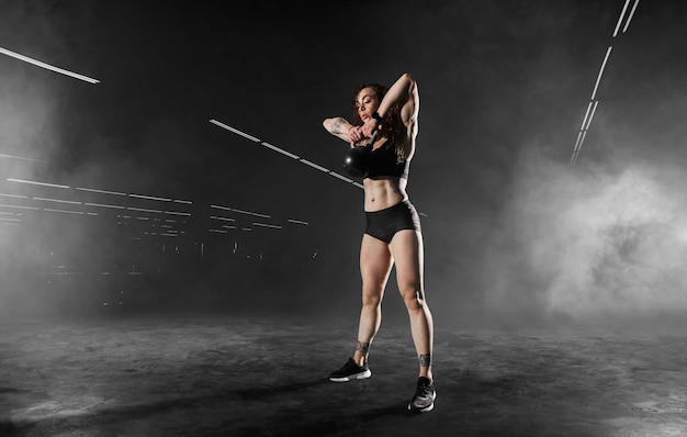 Athletic girl does exercises using sports equipment in a gym