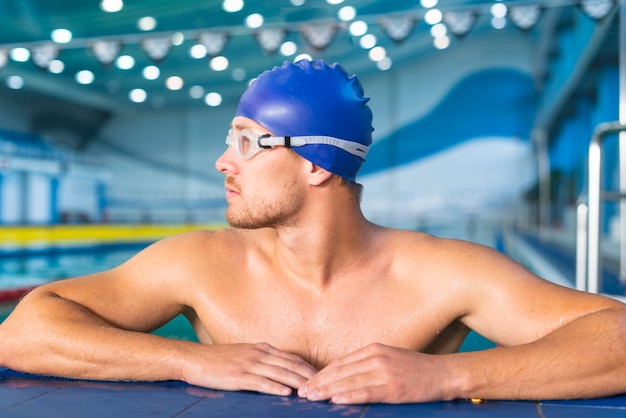 Спортивный мужской пловец смотрит в сторону