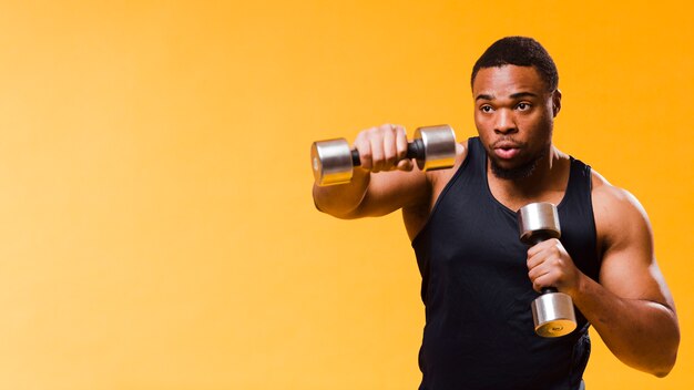 Athletic man exercising with weights