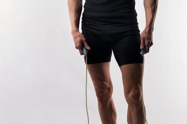 Free photo athletic man holding jumping rope