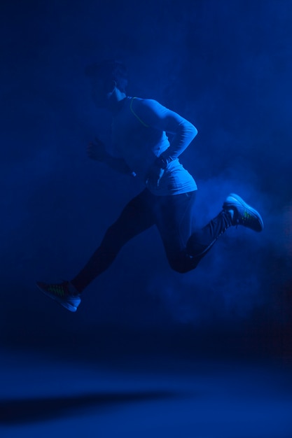 Free photo athletic man jumping in air and steam
