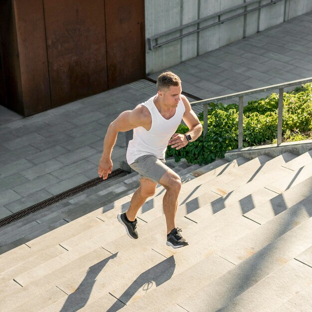 屋外の階段で走っている運動の男