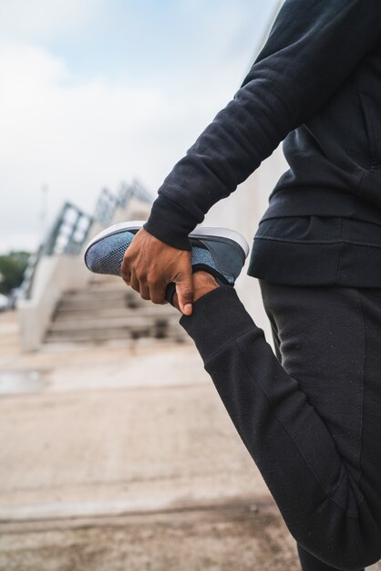 Athletic man stretching legs before exercise.