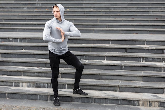 Free photo athletic man warming up his hands