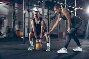 Free photo athletic man and woman with dumbbells