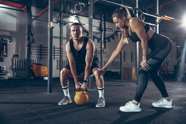 Athletic man and woman with dumbbells