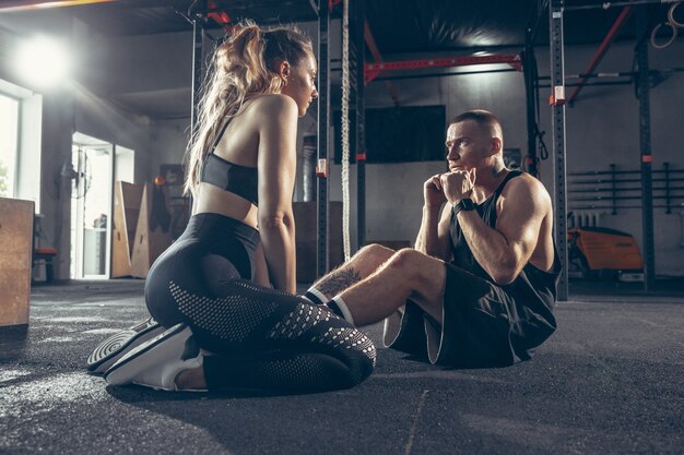 Athletic man and woman with dumbbells