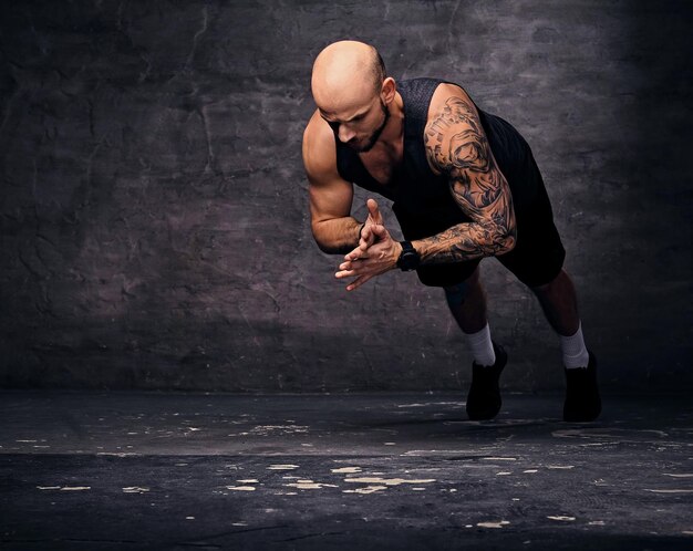 Athletic tattooed, shaved head sporty male doing push ups with jumps.