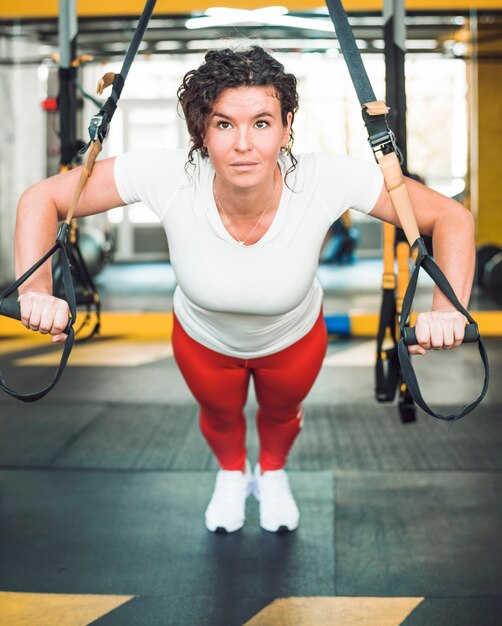 An athletic woman doing workout with fitness strap