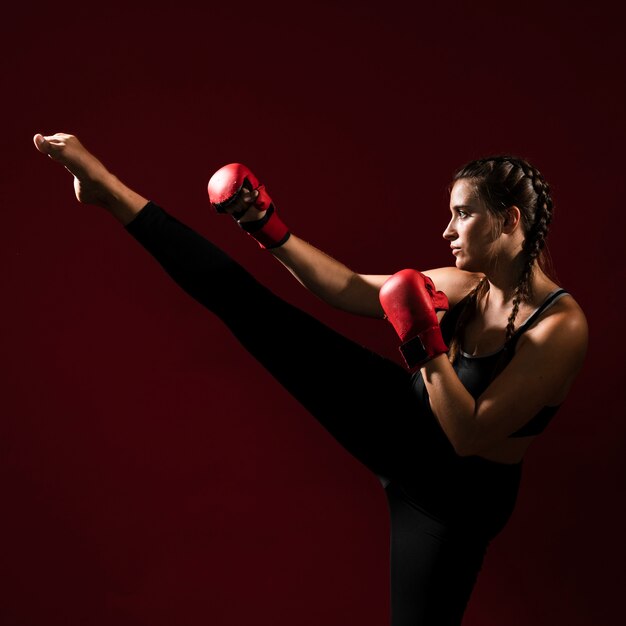 Athletic woman in fitness clothes giving a kick