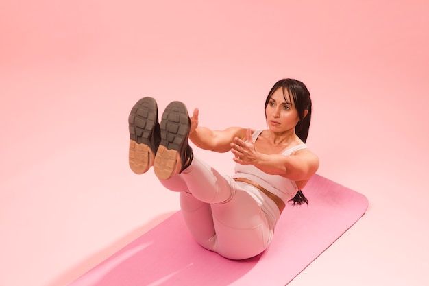 Athletic woman in gym outfit doing crunches