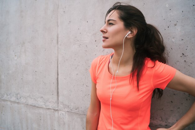 Athletic woman listening to music on a break from training