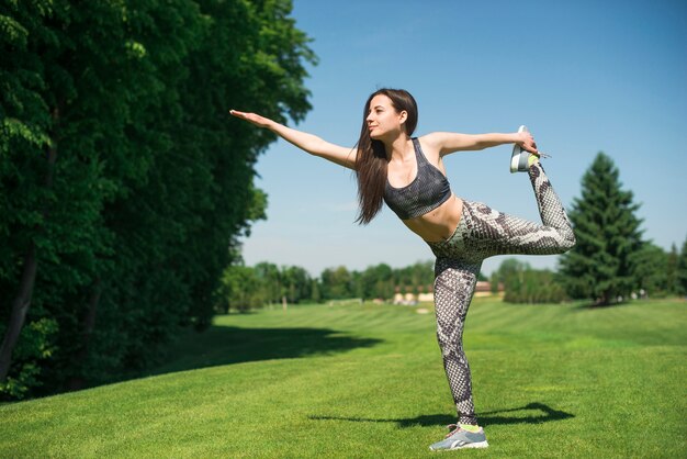 Атлетическая напольная практикуя йога женщины