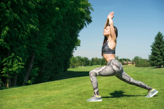Foto gratuita yoga di pratica della donna atletica all'aperto