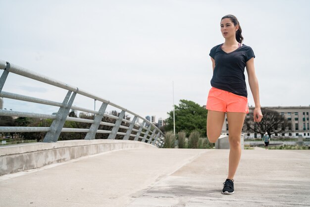 Атлетическая женщина, разминающая ноги перед тренировкой