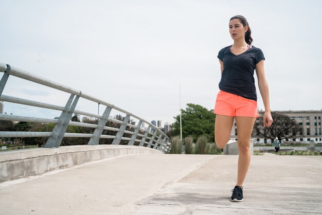 Athletic woman stretching legs before exercise