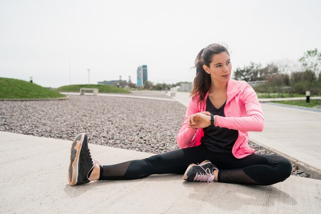 Athletic woman stretching legs before exercise