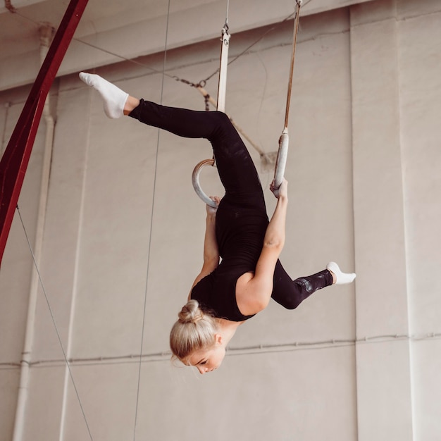 Foto gratuita donna atletica formazione su anelli di ginnastica