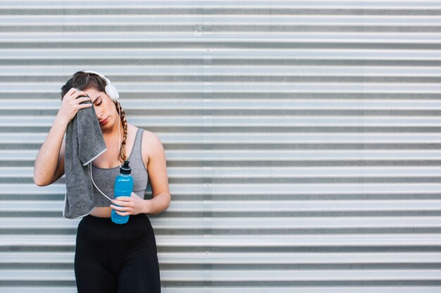 Athletic woman wiping face after workout