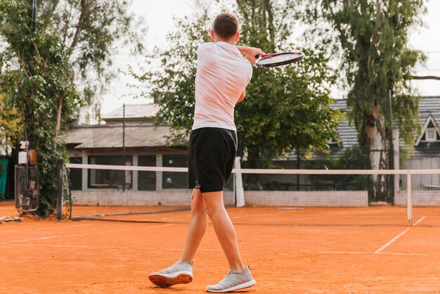 Athletic young boy playing tennis