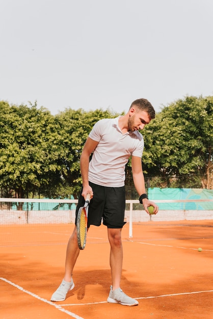 Foto gratuita giovane ragazzo atletico che gioca a tennis